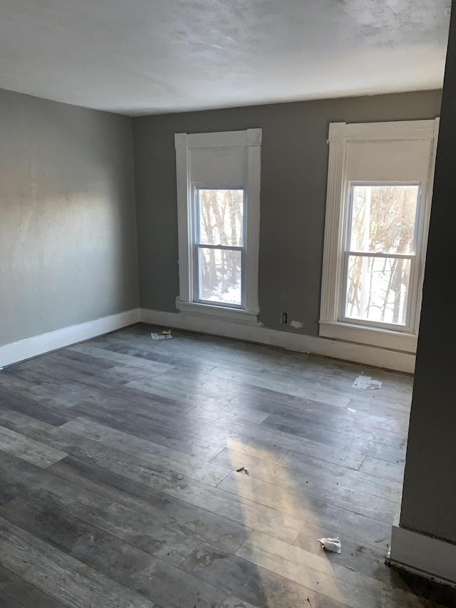 spare room featuring dark hardwood / wood-style floors and a wealth of natural light