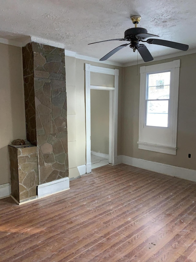 interior space featuring hardwood / wood-style floors, ornamental molding, and a textured ceiling