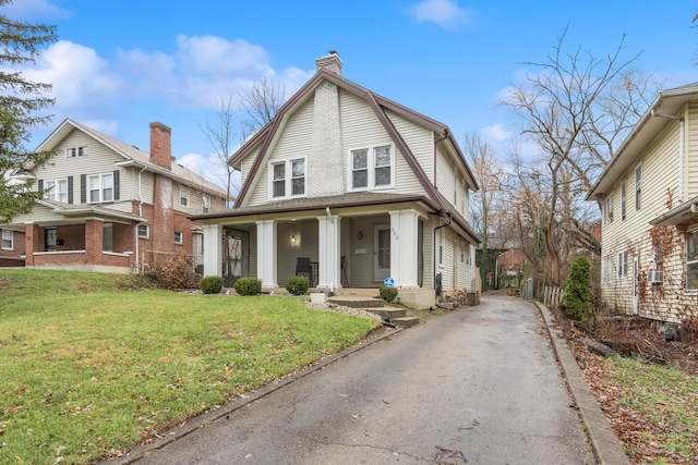 view of front facade featuring cooling unit, covered porch, and a front lawn