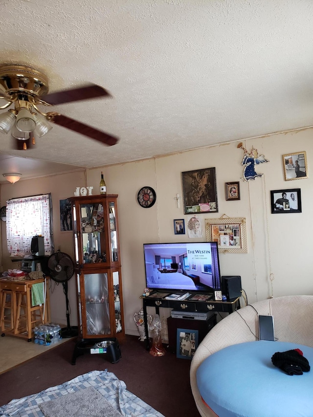 living area with a textured ceiling and ceiling fan