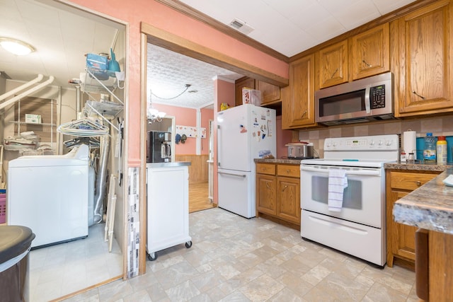 844 Reservoir Rd, Bellefontaine, OH 43311 - kitchen featuring white appliances, washer / clothes dryer, brown cabinetry, and crown molding