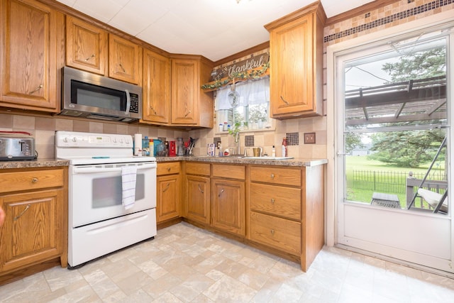 844 Reservoir Rd, Bellefontaine, OH 43311 - kitchen with white range with electric stovetop, stainless steel microwave, decorative backsplash, and brown cabinetry