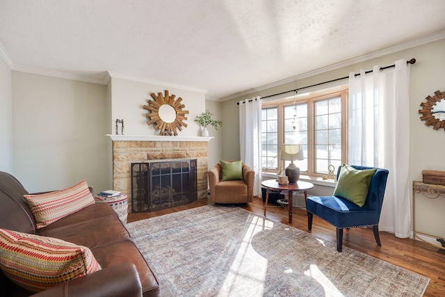 living room with crown molding, wood-type flooring, a fireplace, and a textured ceiling