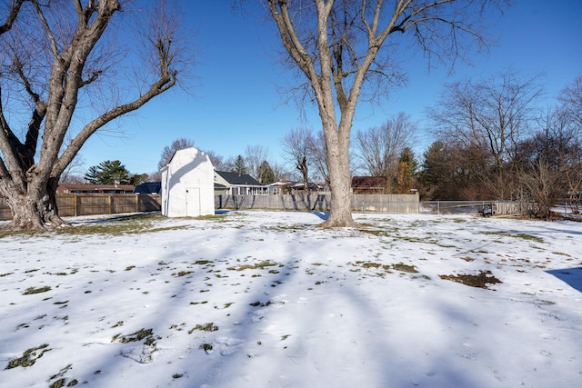 snowy yard featuring a shed