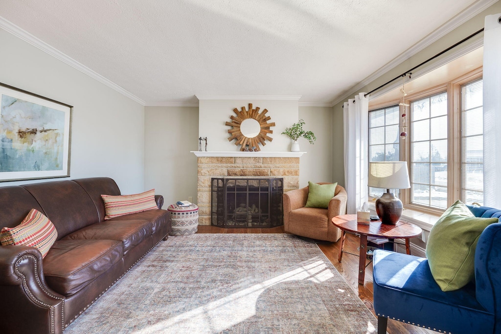 living room with hardwood / wood-style flooring, a fireplace, and ornamental molding