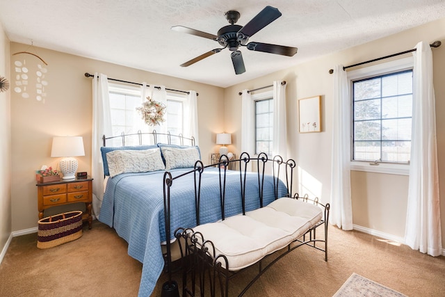 carpeted bedroom with ceiling fan and a textured ceiling