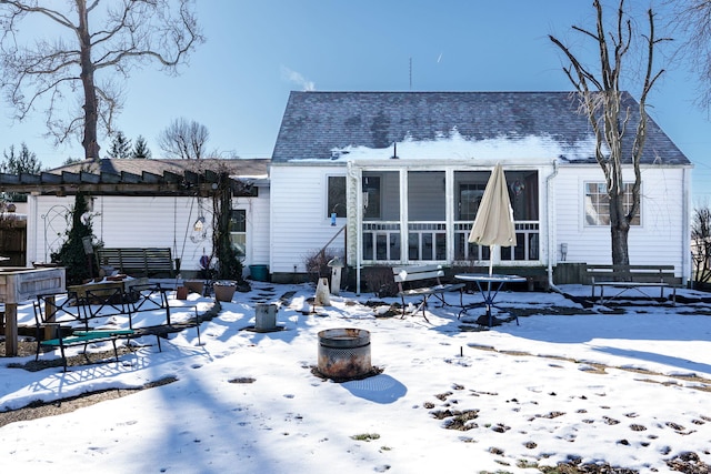 snow covered rear of property featuring a pergola