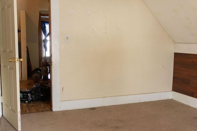 bonus room with lofted ceiling and carpet flooring