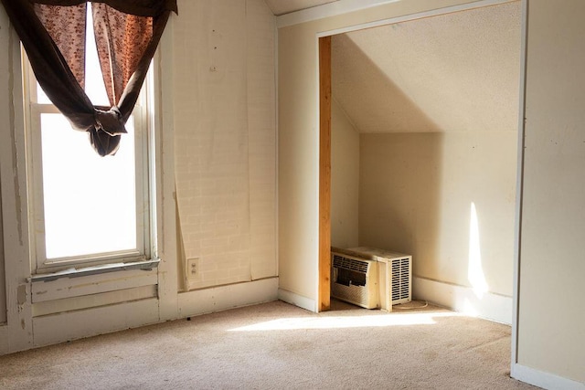 bonus room featuring vaulted ceiling, a wall mounted air conditioner, and light colored carpet