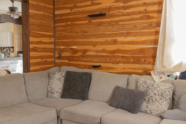 living room featuring wooden walls and ceiling fan