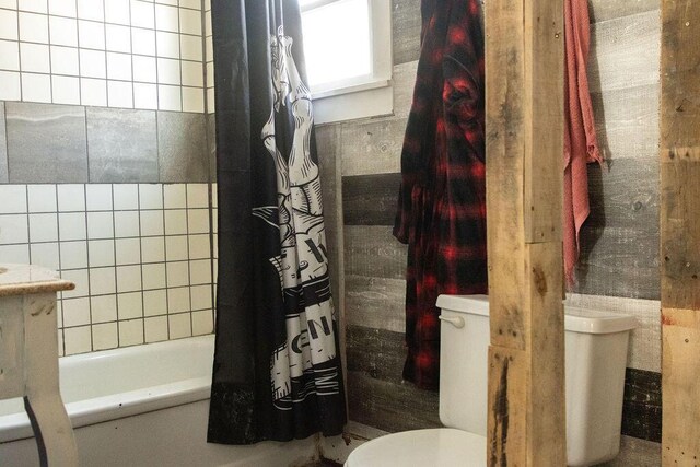 bathroom with shower / bathtub combination with curtain and toilet