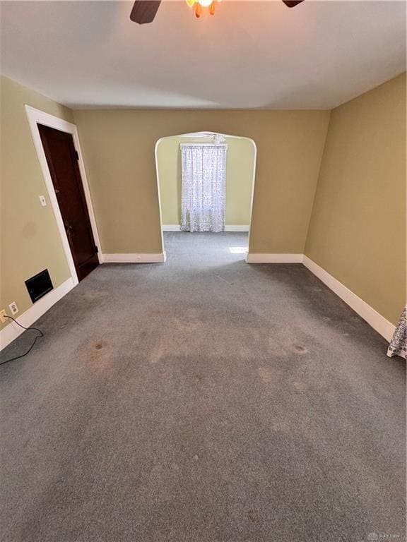 230 New Columbia Blvd, Sidney, OH 45365 - unfurnished room featuring a ceiling fan, arched walkways, baseboards, and dark carpet