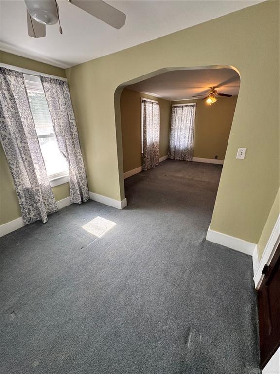 230 New Columbia Blvd, Sidney, OH 45365 - unfurnished room with arched walkways, carpet flooring, and a ceiling fan