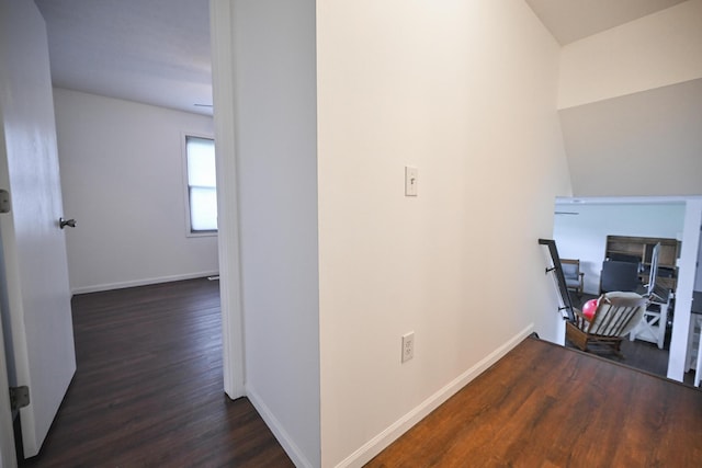 corridor featuring baseboards and wood finished floors