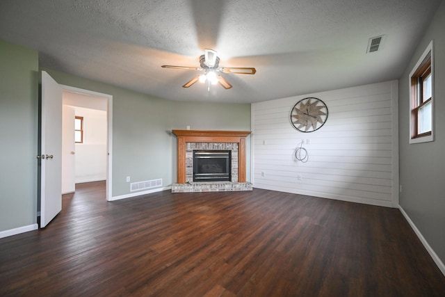 unfurnished living room with ceiling fan, visible vents, and dark wood-type flooring