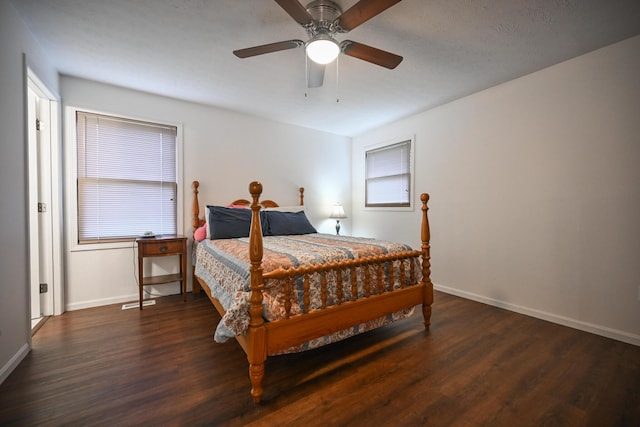 bedroom with baseboards, wood finished floors, and multiple windows