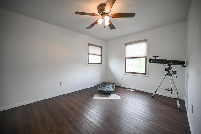 interior space with baseboards, ceiling fan, and wood finished floors