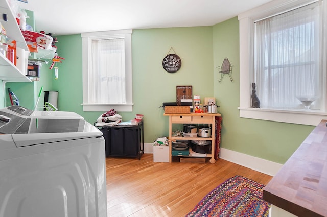 laundry area with washer and clothes dryer and light hardwood / wood-style flooring