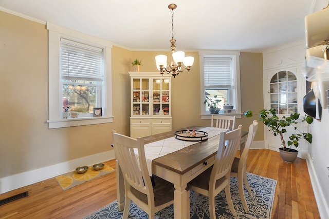 dining area with hardwood / wood-style floors and a notable chandelier