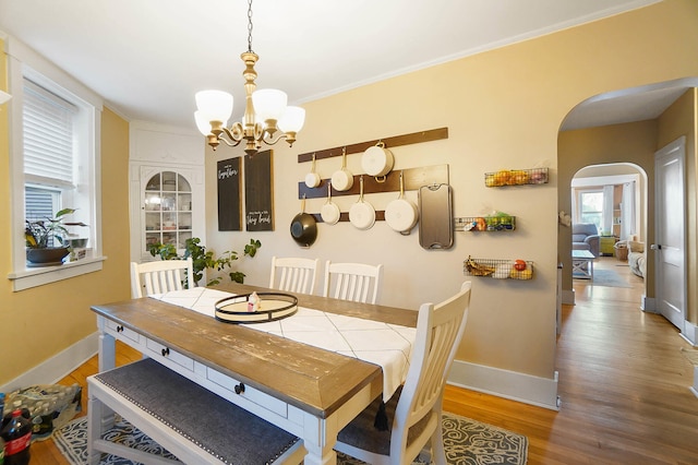 dining area featuring ornamental molding, a notable chandelier, and light hardwood / wood-style floors