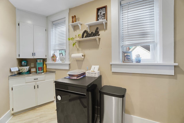 kitchen with white cabinetry, a wealth of natural light, and light hardwood / wood-style floors