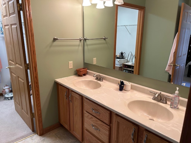 bathroom with a sink, double vanity, and tile patterned floors