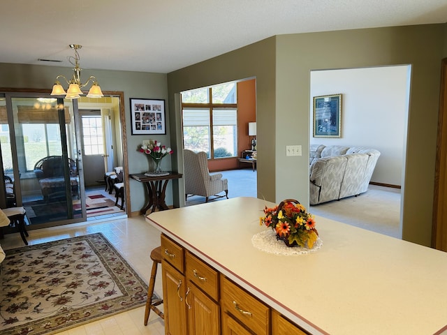 kitchen with a notable chandelier, plenty of natural light, light countertops, and open floor plan