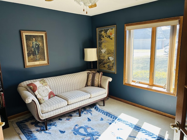 sitting room with baseboards, plenty of natural light, and carpet floors