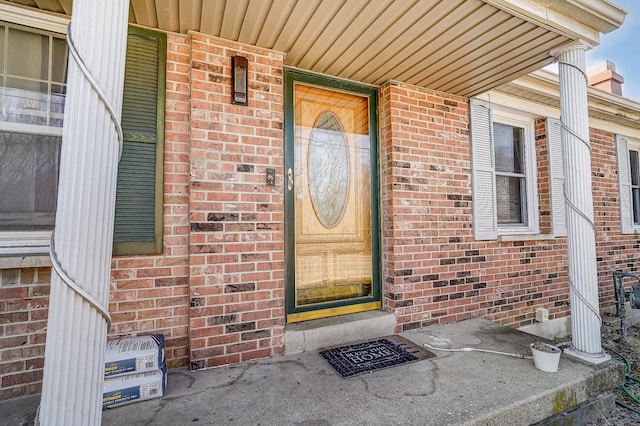 doorway to property featuring brick siding