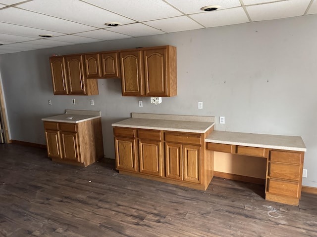 kitchen with dark wood-type flooring and a drop ceiling