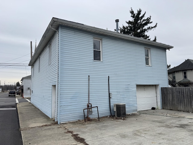 exterior space with a garage and central air condition unit