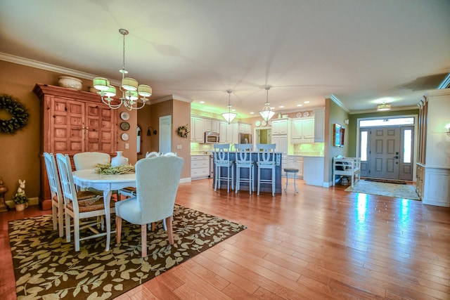 1205 Daylily Way, Troy, OH 45373 - dining area featuring a chandelier, crown molding, and light wood-style flooring