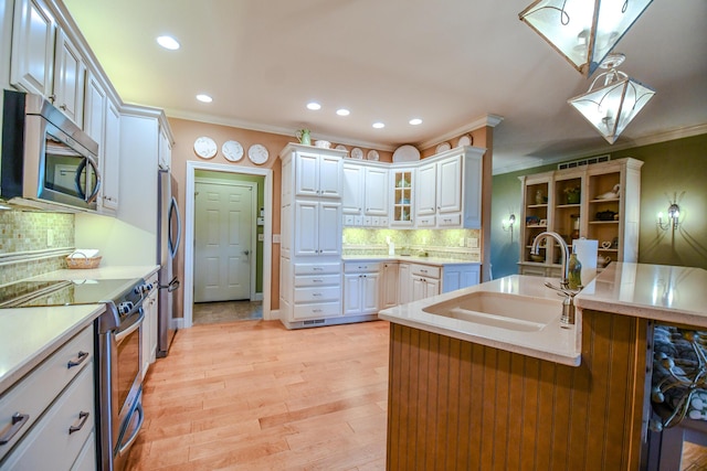 1205 Daylily Way, Troy, OH 45373 - kitchen with stainless steel appliances, ornamental molding, recessed lighting, light countertops, and decorative backsplash