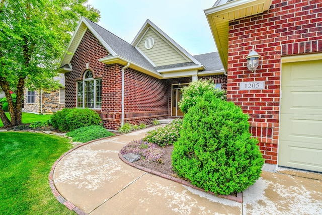 1205 Daylily Way, Troy, OH 45373 - property entrance featuring brick siding, a shingled roof, a lawn, and an attached garage