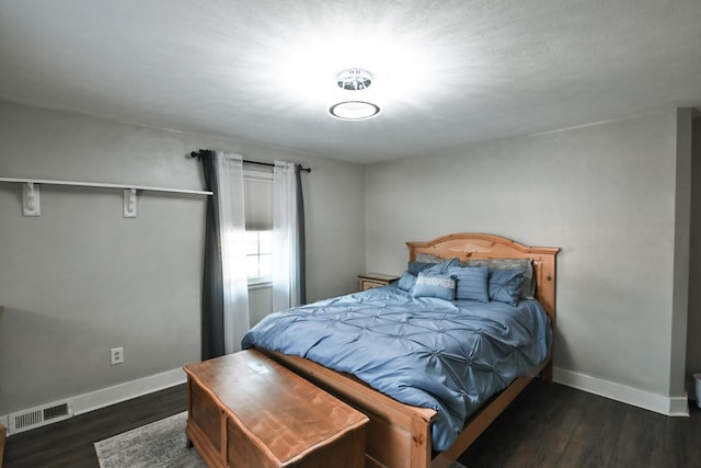 bedroom featuring wood finished floors, visible vents, and baseboards