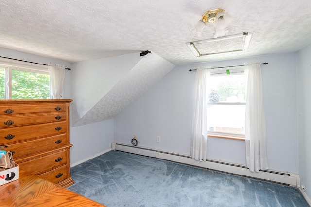 additional living space with attic access, a healthy amount of sunlight, carpet floors, and baseboard heating