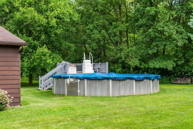 view of pool with a covered pool, a yard, and a wooden deck