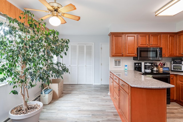 kitchen featuring black / electric stove, light wood-type flooring, light stone countertops, and tasteful backsplash