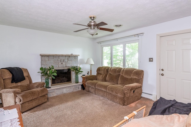 carpeted living room featuring a baseboard radiator, a stone fireplace, visible vents, and a textured ceiling