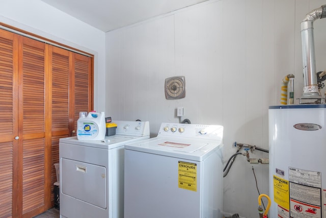 clothes washing area with water heater, laundry area, and washing machine and dryer