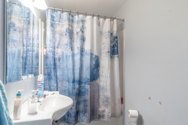 bathroom with a shower with shower curtain and a sink