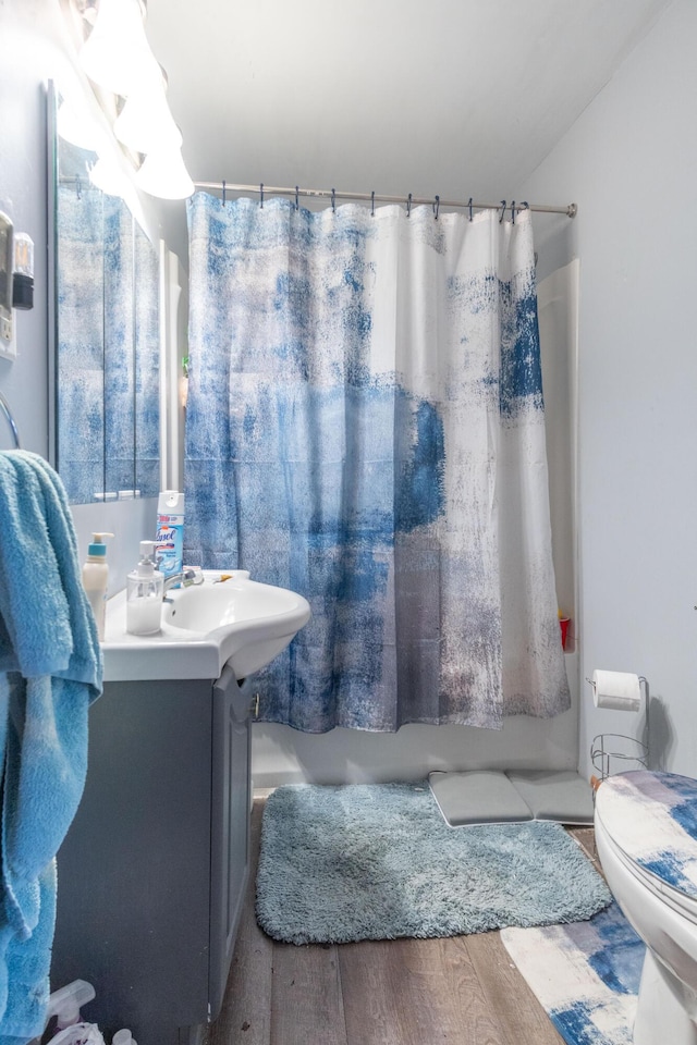 bathroom with toilet, shower / bath combo, wood finished floors, and vanity