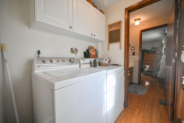 5283 Willow Dale Rd, Urbana, OH 43078 - laundry room with cabinet space, light wood-style floors, and washing machine and clothes dryer