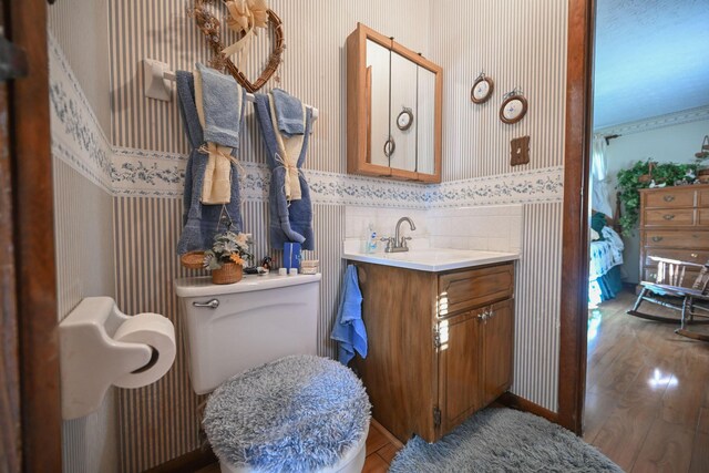 5283 Willow Dale Rd, Urbana, OH 43078 - bathroom with wallpapered walls, wood finished floors, vanity, and toilet