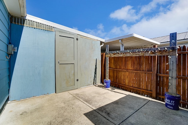 view of patio with a shed, an outdoor structure, and fence