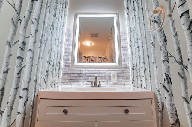 bathroom with vanity, visible vents, and backsplash