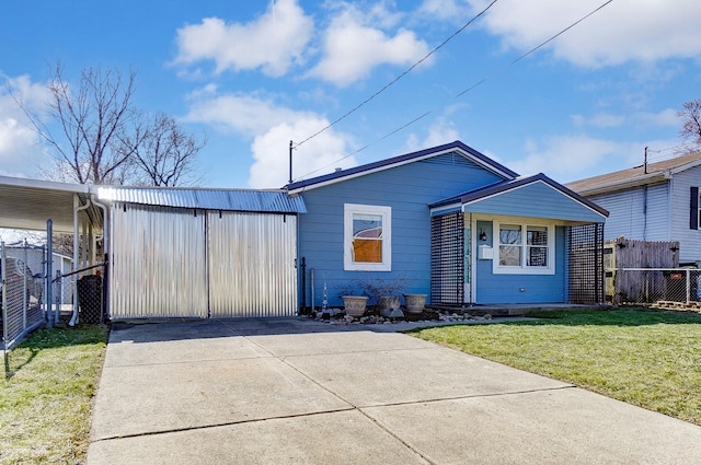 view of front of house featuring driveway, a front lawn, and fence