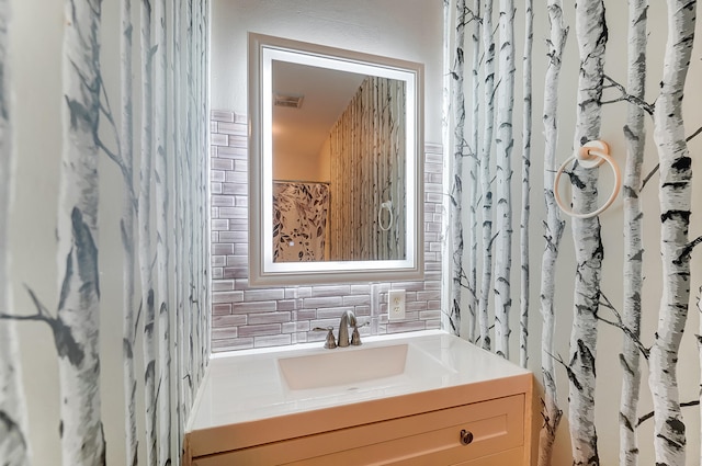 bathroom with visible vents, vanity, and decorative backsplash