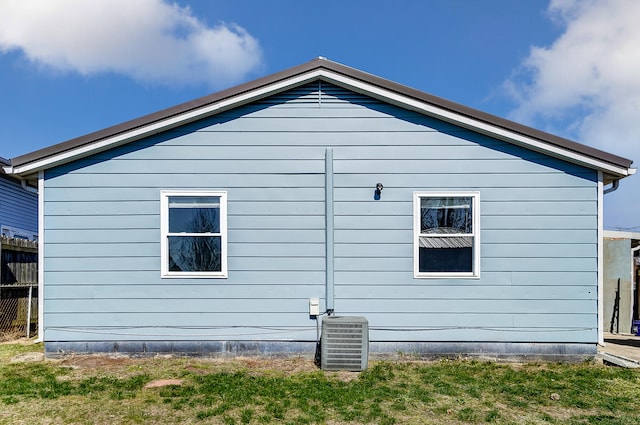 back of property featuring central AC and fence