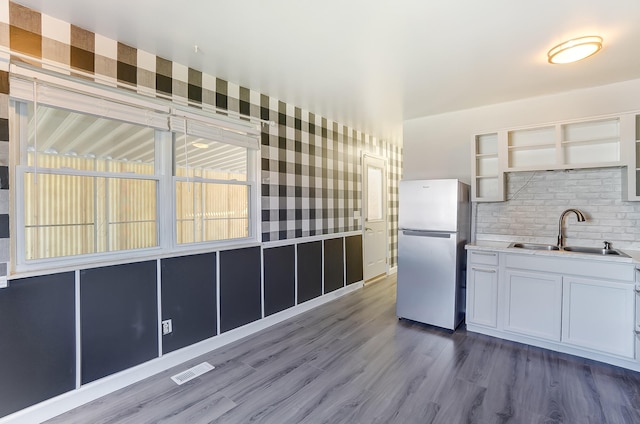 kitchen with visible vents, a sink, freestanding refrigerator, dark wood-style floors, and open shelves